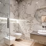 Contemporary bathroom featuring marble walls, a round mirror, and modern fixtures.