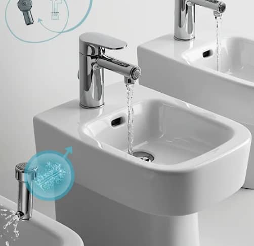 Contemporary bidet faucet with water flowing into a white basin in a clean design.