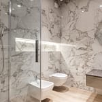 Contemporary bathroom featuring marble walls, a round mirror, and modern fixtures.