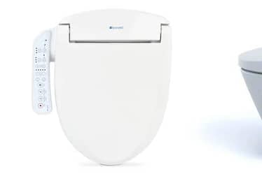 White bidet toilet attachment with remote control on the side and a modern toilet design.