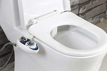 White bidet toilet attachment with control panel on the side, featuring two knobs for water control.
