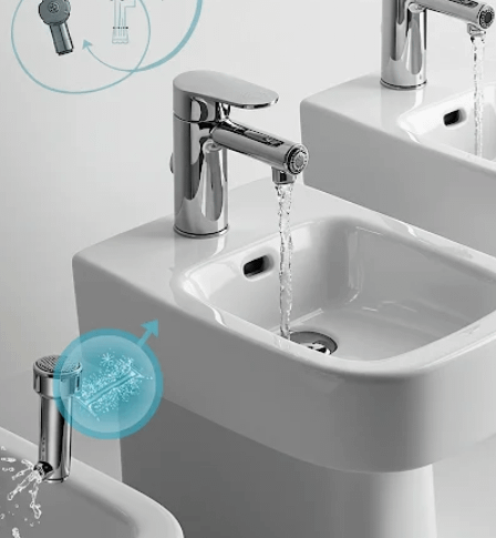 Contemporary bidet faucet with water flowing into a white basin in a clean design.