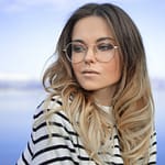 woman wearing black and white striped top and round eyeglasses